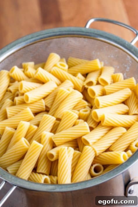 One-Pot Pizza Magic 5 A strainer of cooked rigatoni pasta.