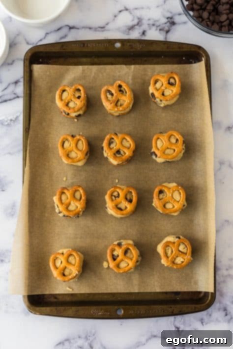 pretzels with cookie dough in between them and layered on a baking sheet.
