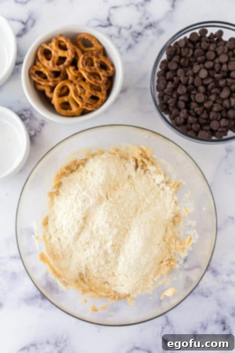 Flour on top of creamed butter and sugar in a mixing bowl.