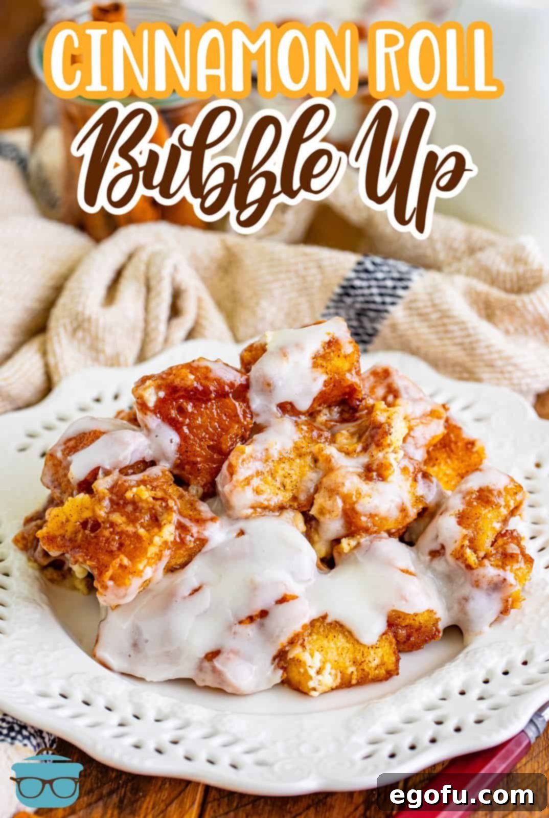 A perfectly portioned serving of warm Cinnamon Roll Bubble Up on a white plate, glistening with cream cheese glaze, ready to be enjoyed.