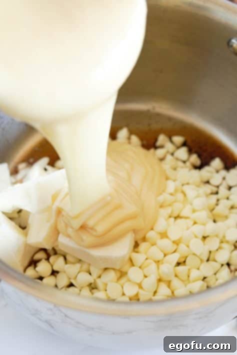 A saucepan with browned butter, white chocolate chips, white almond bark, and sweetened condensed milk.