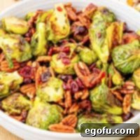 Crispy Holiday Brussels Sprouts 9 Close up looking at a bowl of Roasted Brussels Sprouts, showcasing the crispy bacon and pecans.