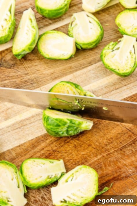 Crispy Holiday Brussels Sprouts 10 A knife cutting a brussel sprout.