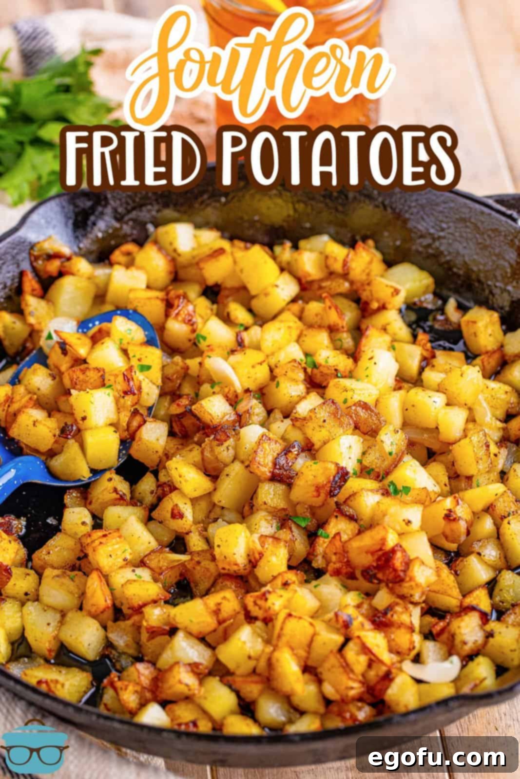 A pan of Southern Fried Potatoes with a serving spoon in the potatoes.