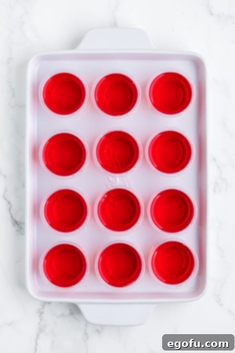 Spirited Santa Hat Shooters 11 Strawberry jello shots on a tray.