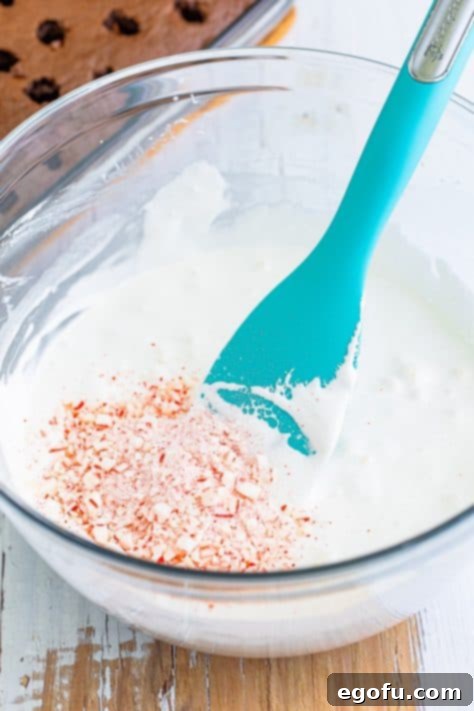 Crushed peppermint candies in a bowl of milk and marshmallow creme.