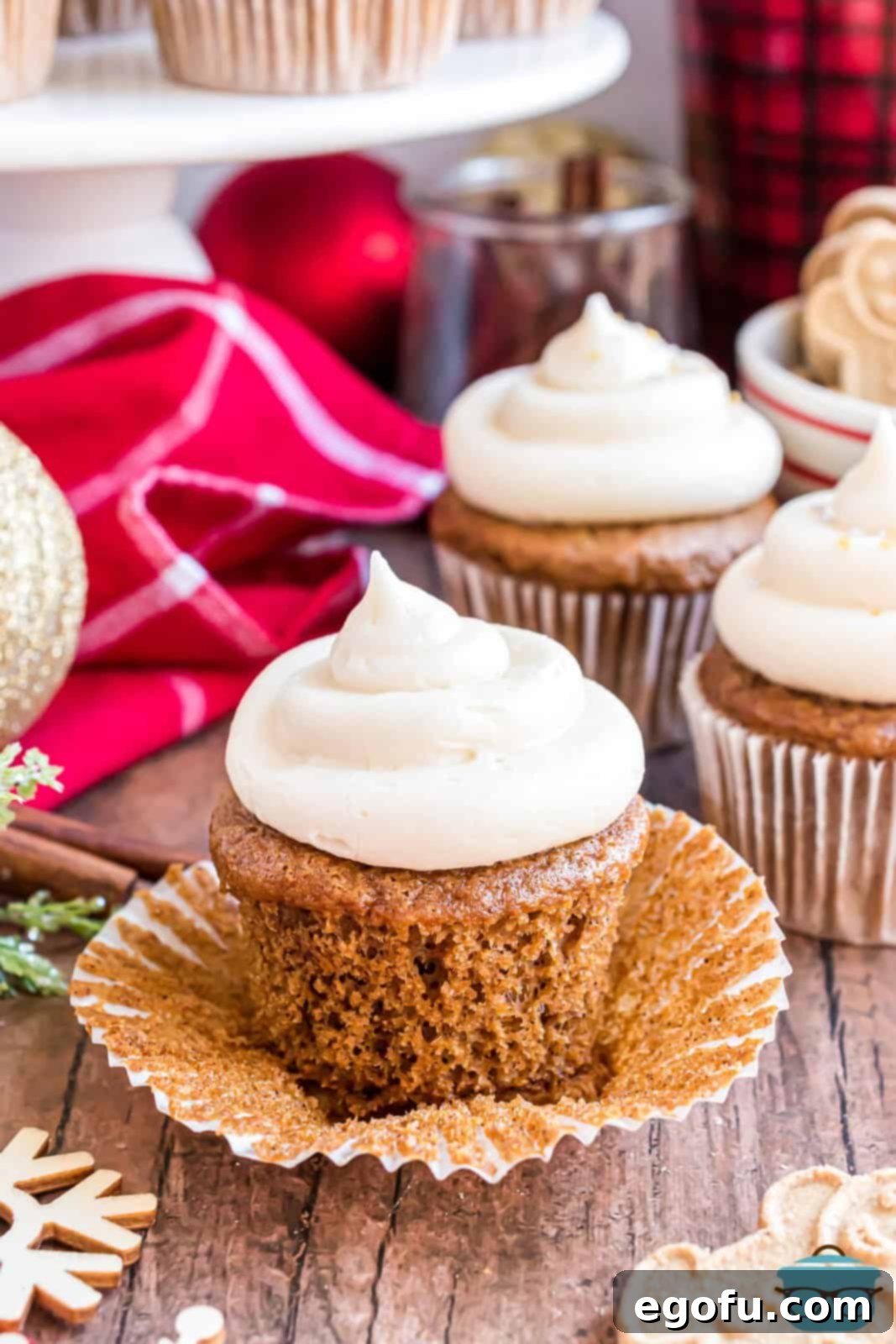 Cozy Gingerbread Cupcakes 2 A Gingerbread Cupcake with the wrapper pulled down, showcasing its moist texture and rich frosting.