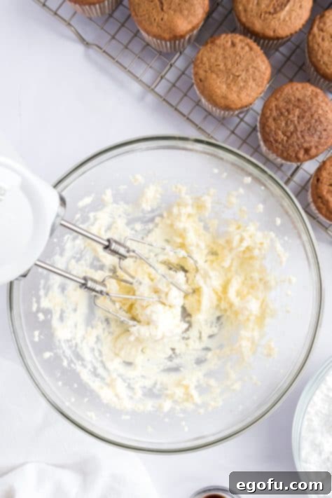 Cozy Gingerbread Cupcakes 12 Cream cheese and butter being mixed in a bowl.
