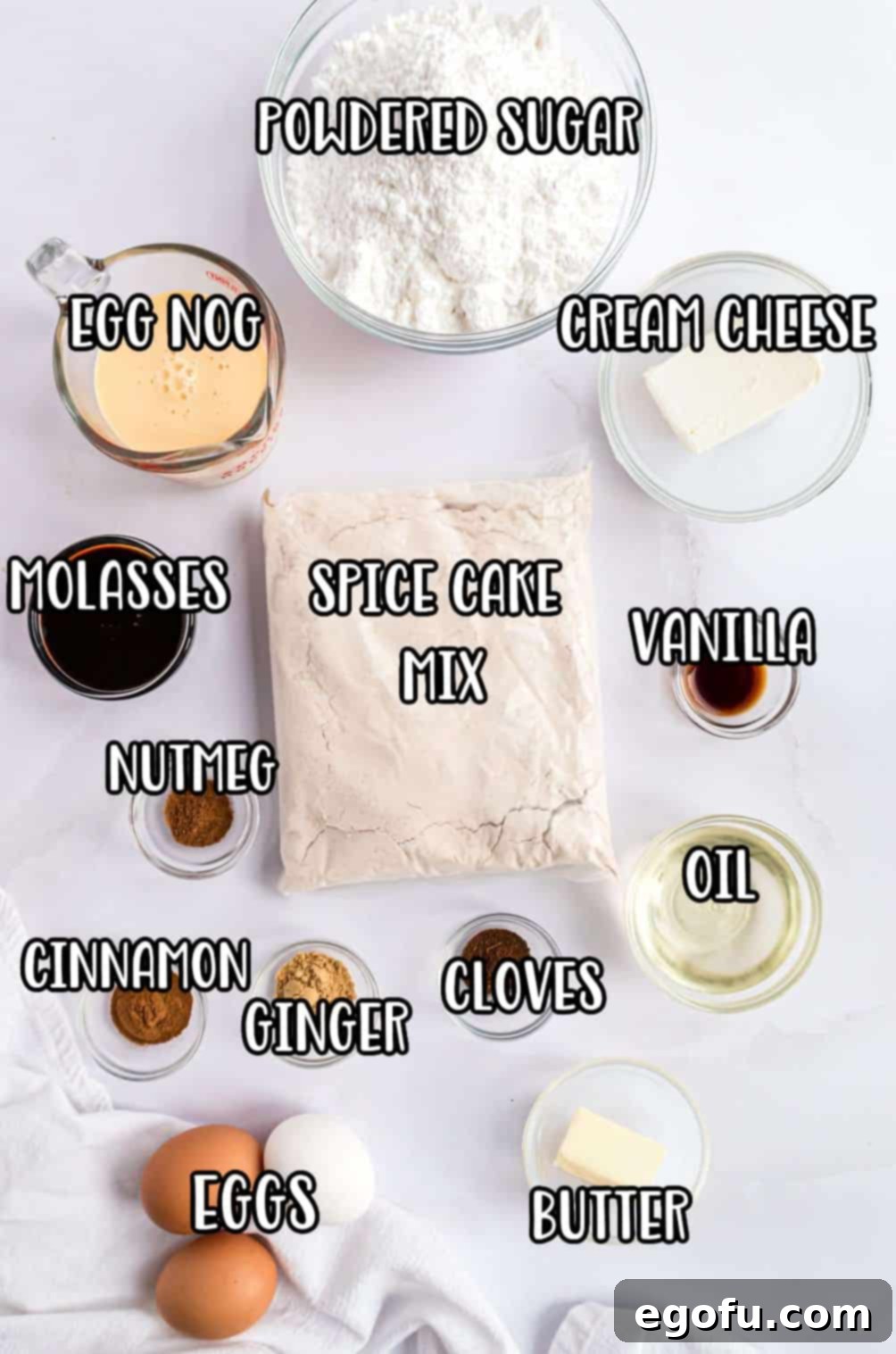 Cozy Gingerbread Cupcakes 4 A selection of ingredients for Gingerbread Cupcakes: spice cake mix, eggs, oil, ground ginger, cinnamon, cloves, nutmeg, molasses, eggnog, cream cheese, unsalted butter, powdered sugar, and vanilla extract.
