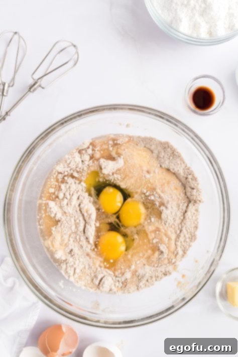 Cozy Gingerbread Cupcakes 10 A mixing bowl with spice cake mix, ginger, cinnamon, cloves, nutmeg, eggnog, oil, eggs, and molasses.