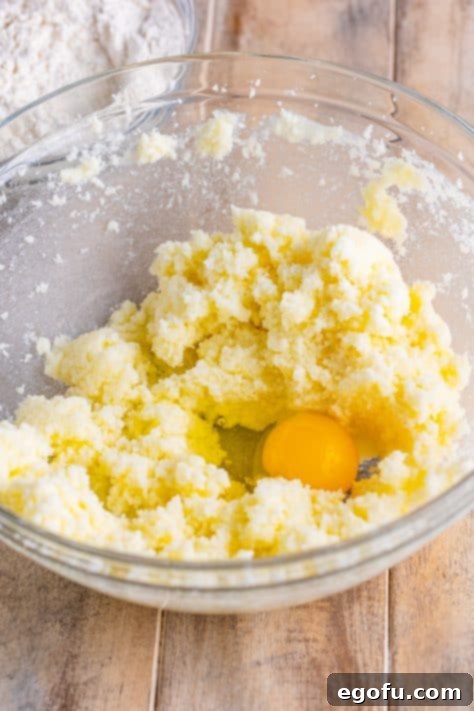 Eggs being added one by one to the butter and sugar mixture.
