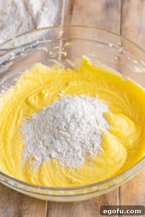 Flour mixture being added to wet ingredients for a Southern Pound Cake.