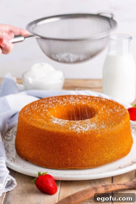 Sprinkling powdered sugar on top of southern pound cake.