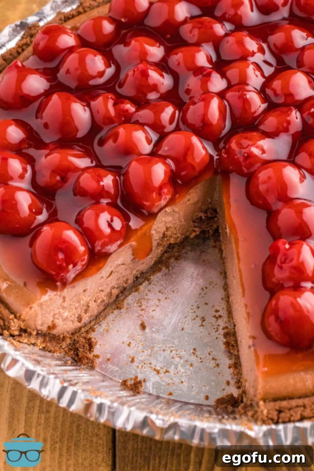 Decadent Cherry Chocolate Cheesecake 2 A Cherry Chocolate Cheesecake with a slice removed, revealing its creamy layers.