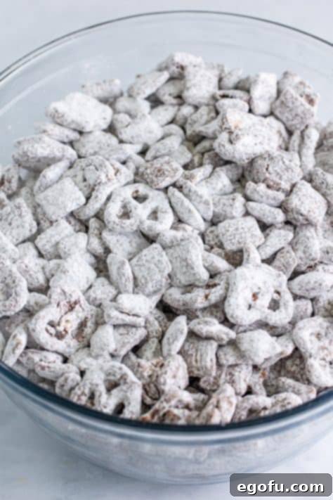 Chex Mix Muddy Buddies in a glass mixing bowl.