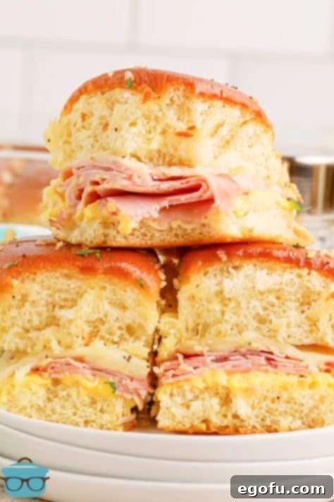 Three Honey Mustard Ham Sliders in a pile on a plate.