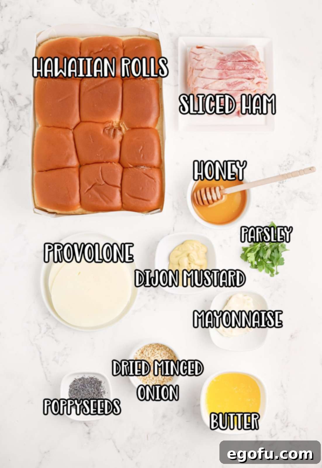 All the ingredients for Honey Mustard Ham Sliders laid out: Hawaiian rolls, mayonnaise, deli ham, provolone cheese, honey, Dijon mustard, butter, dried onion, poppy seeds, and fresh parsley.