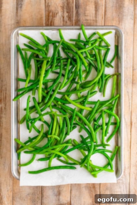 Green beans on a paper towel lined baking sheet.