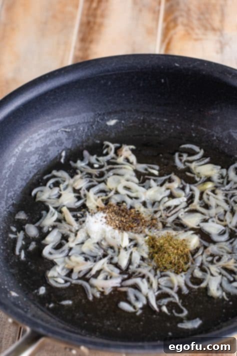 Shallots and spices in a pan.