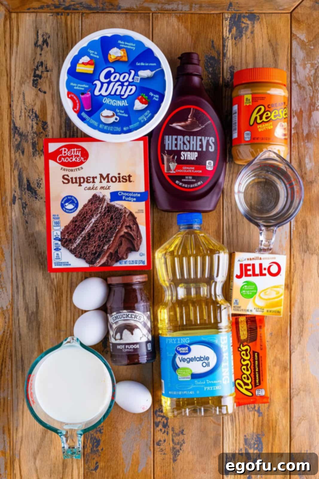 Chocolate cake mix, chocolate syrup, Reese's Peanut BUtter, water, oil, eggs, Cool Whip, Vanilla pudding mix, hot fudge sauce, Reese's cups, and milk.