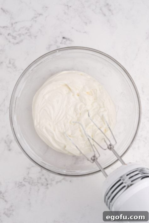 Reese's Peanut Butter Cheesecake Minis 11 Cream cheese and sour cream being mixed together in a bowl.