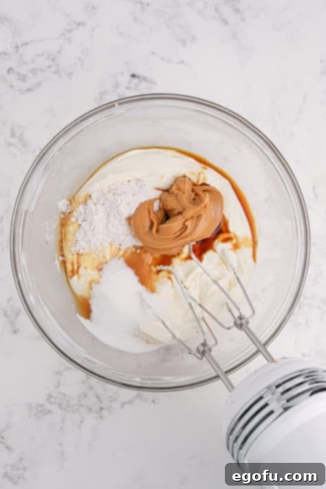 Reese's Peanut Butter Cheesecake Minis 12 Cream cheese, sour cream, granulated sugar, peanut butter, flour, and vanilla extract in a mixing bowl.