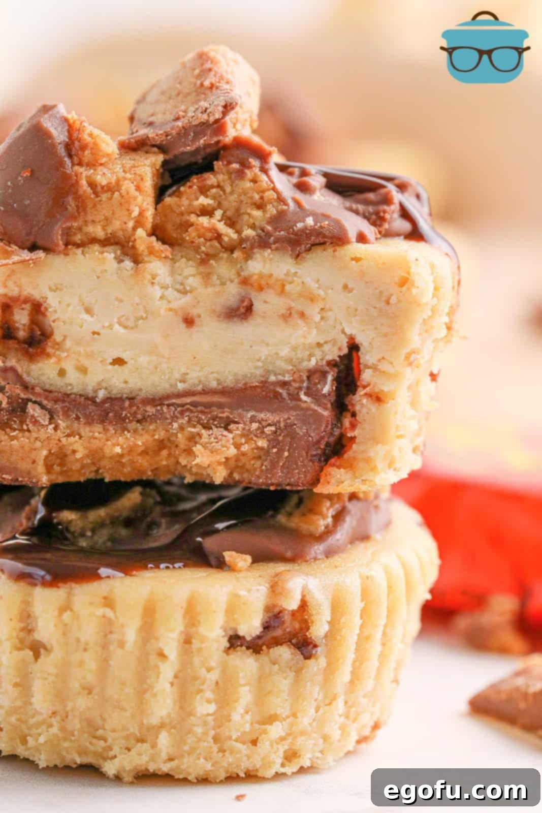 Reese's Peanut Butter Cheesecake Minis 8 A close-up shot of two Reese's Mini Cheesecakes, one broken in half to reveal the creamy peanut butter filling and the Reese's cup base.