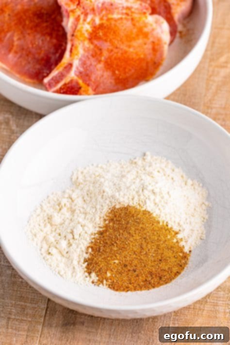 A bowl with flour, salt, garlic powder, onion powder, paprika, pepper, and cayenne.