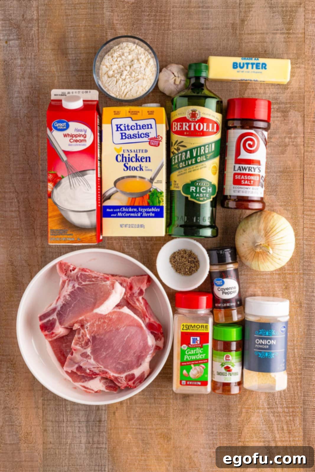 Bone in pork chops, sweet onion, heavy cream, unsalted butter, seasoned salt, garlic powder, onion powder, smoked paprika, black pepper, cayenne pepper, flour, olive oil, garlic cloves, and chicken stock.
