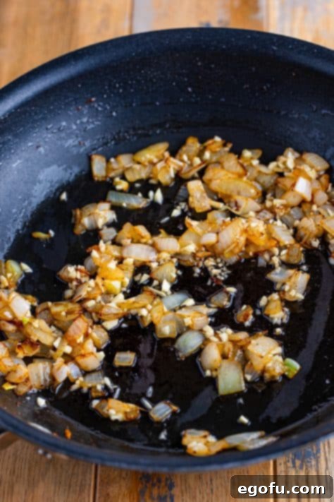 Velvety Chicken and Mushroom Feast 13 Cooked onion and garlic in a skillet.