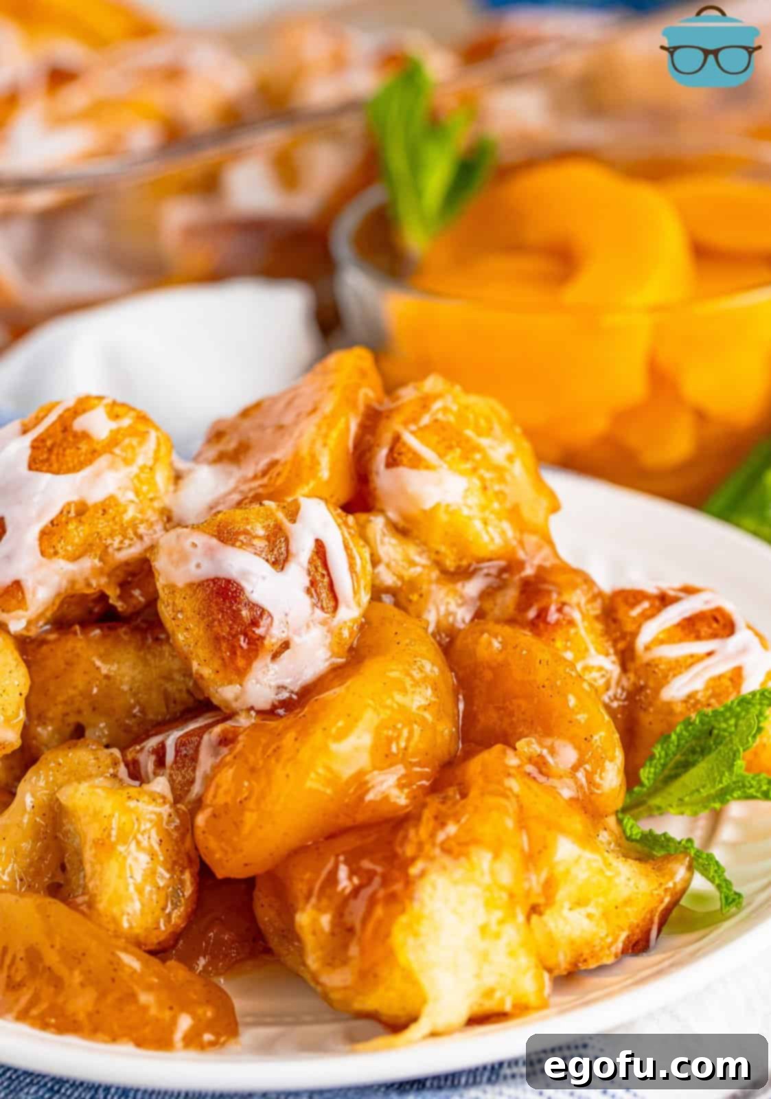 Close up looking at Peach Dumpling Bubble Up on a plate, showcasing its golden crust and juicy peach filling.