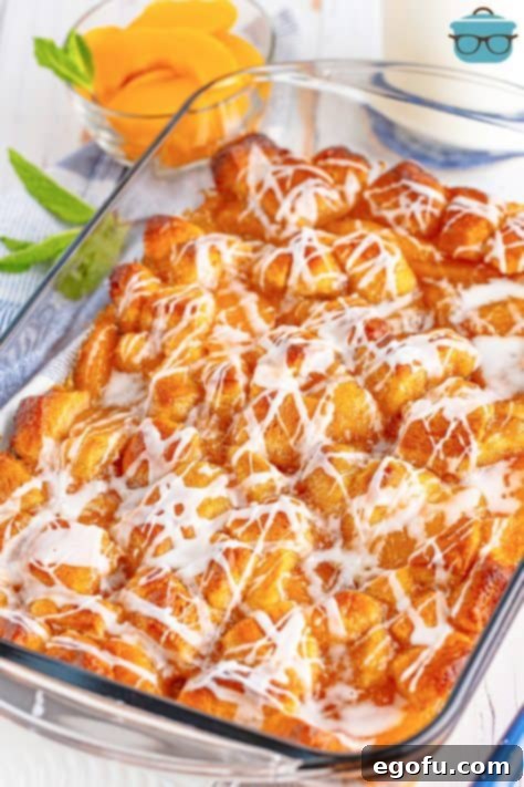 icing poured over baked peach bubble up.