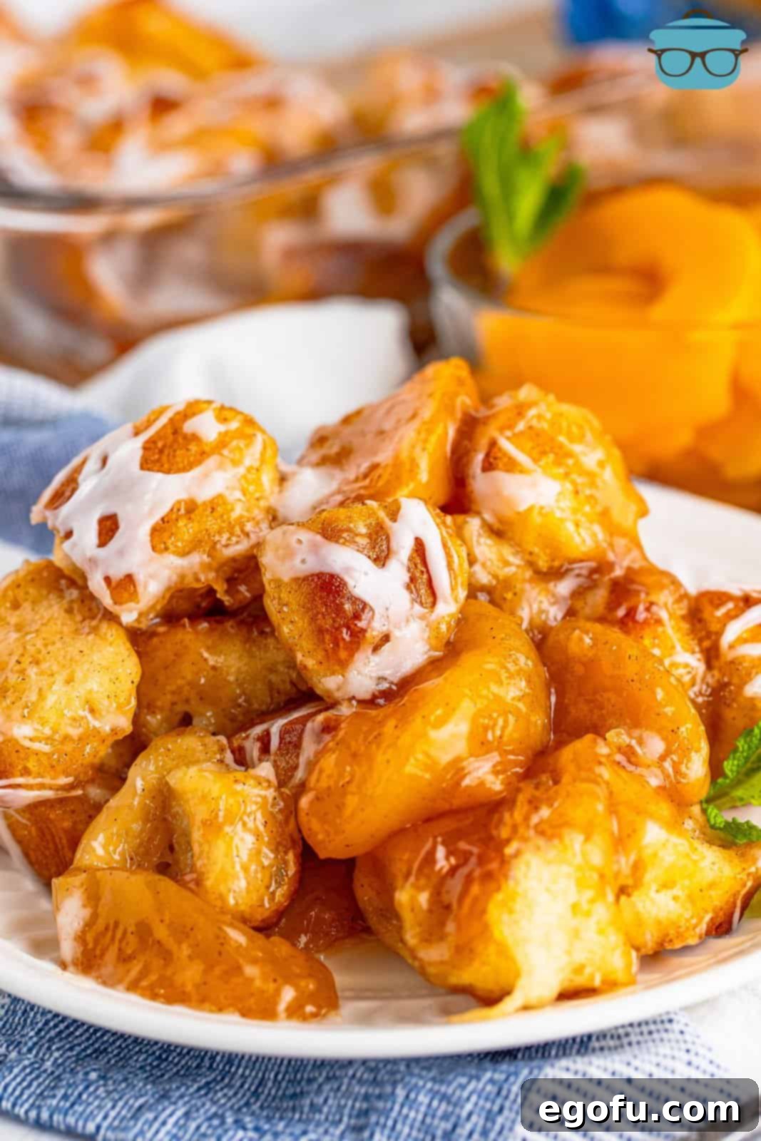 A white plate with a large serving of Peach Bubble Up with sweet glaze, ready to be enjoyed.