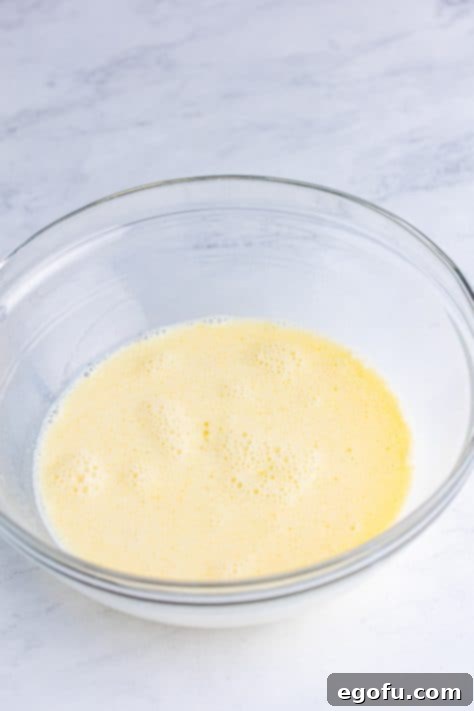 A mixing bowl with milk, egg, oil, and honey.