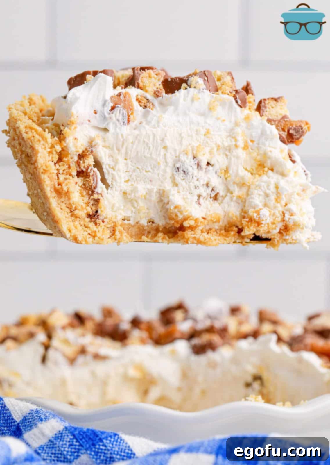 A slice of No Bake Twix Pie being held above the rest of the pie.