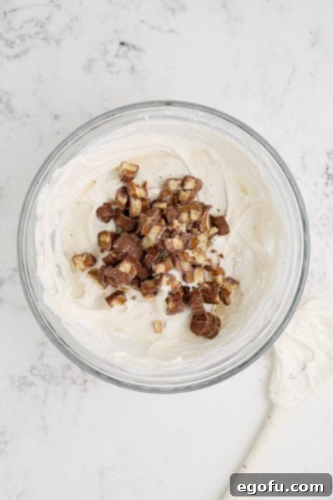 Chopped Twix added to the pie filing in a bowl.