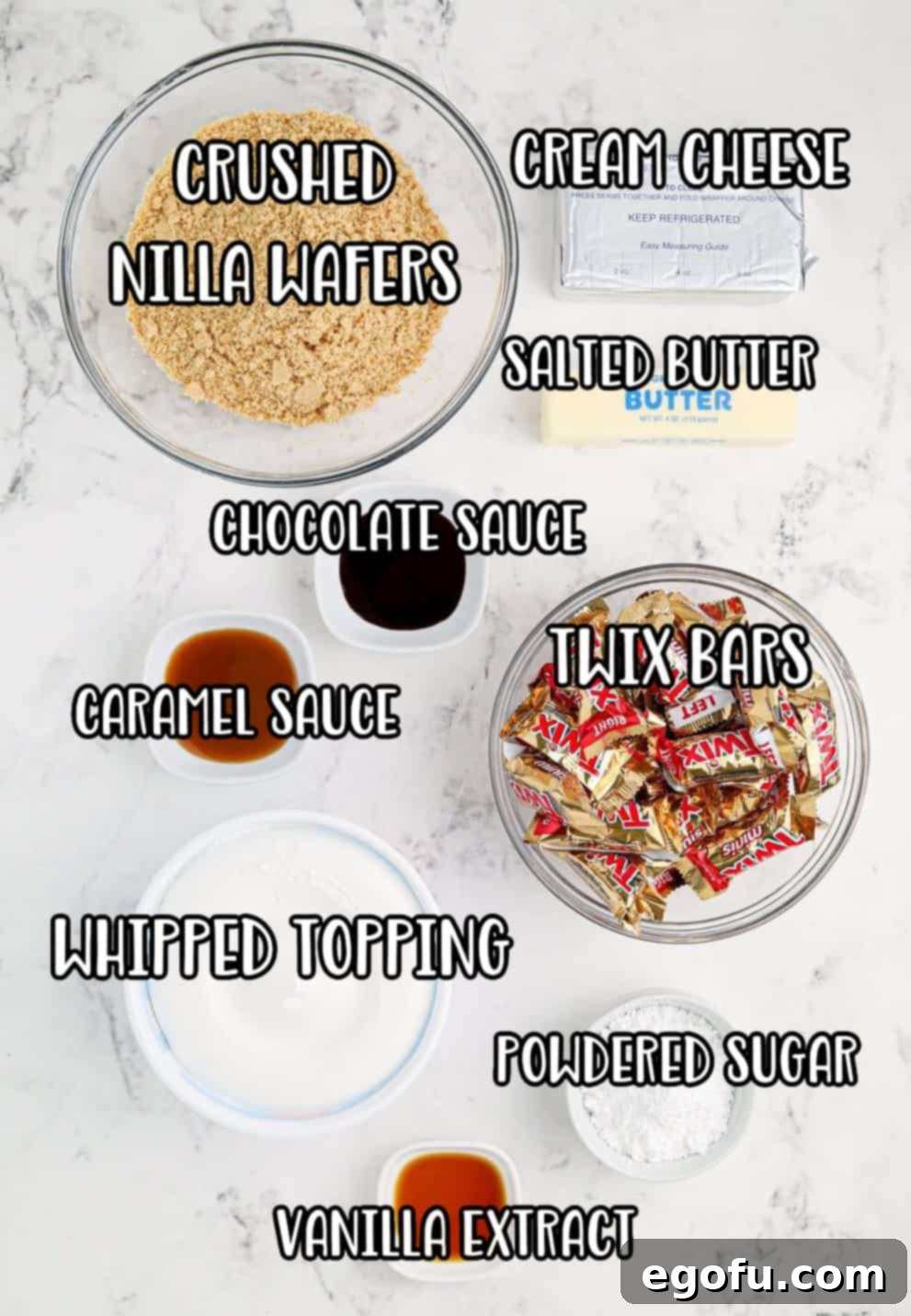 Nilla wafer crumbs, butter, cream cheese, powdered sugar, vanilla extract, whipped topping, Twix bars, and choclate sauce.