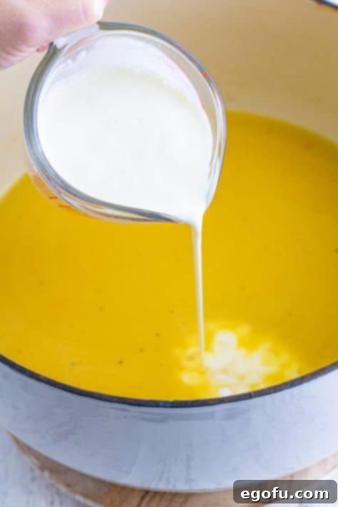 heavy cream being poured into dutch oven.