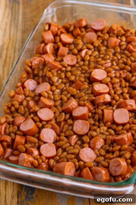 Hot dogs and beans spread out in a baking dish.