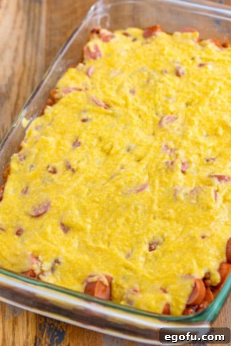 Cornbread mixture on top of bean and hot dog mixture.