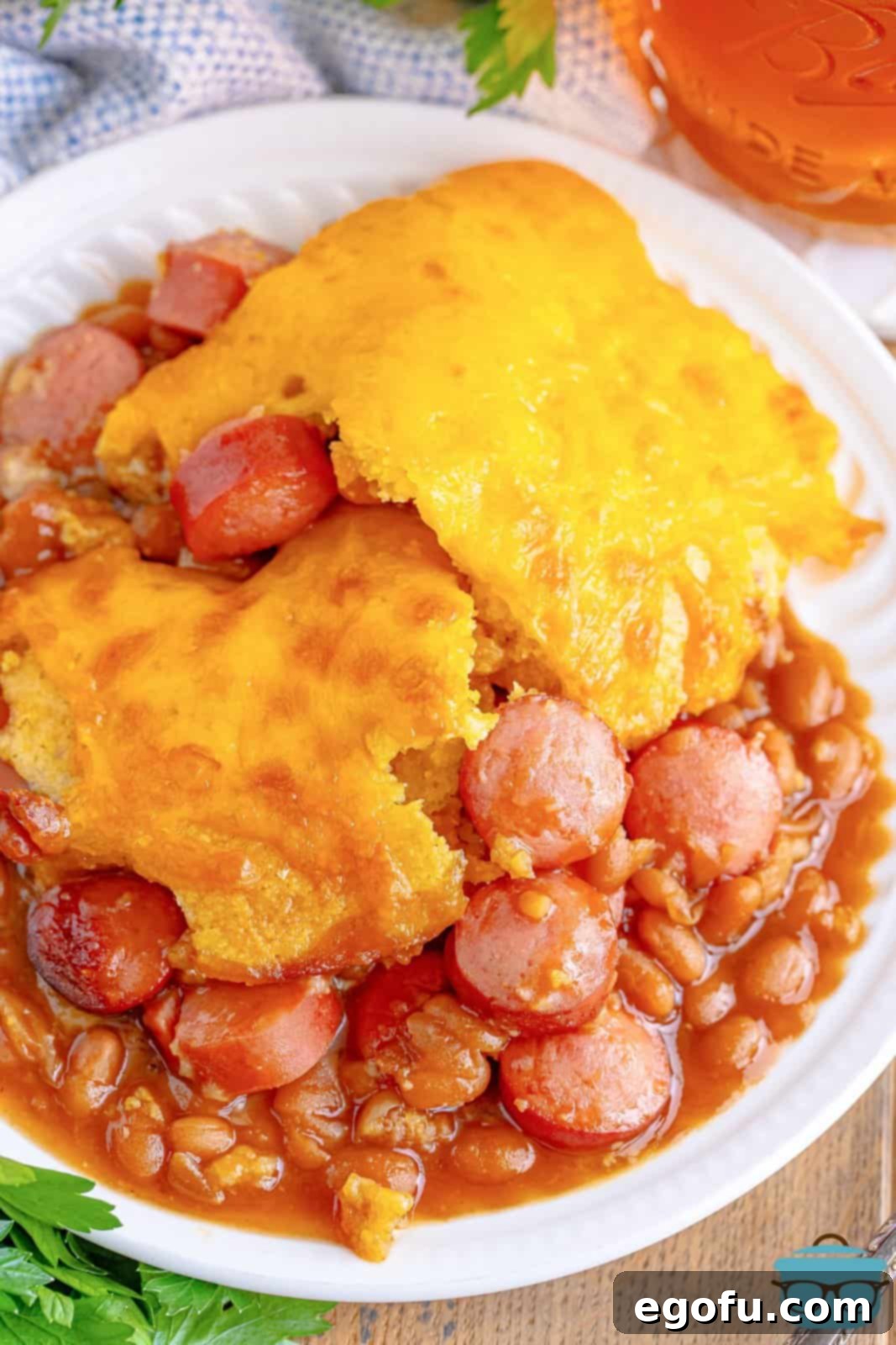 Looking down on a perfectly plated serving of Beanie Weenie Casserole on a white dish, ready to be enjoyed.