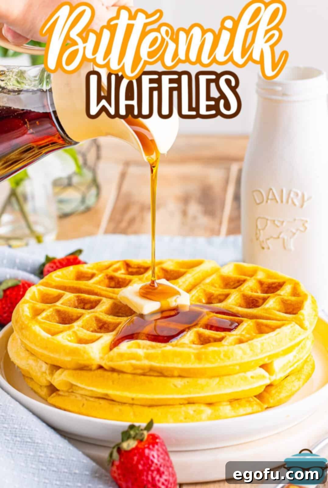 Syrup being poured generously over a small stack of golden-brown buttermilk waffles, creating an appetizing cascade of sweetness.