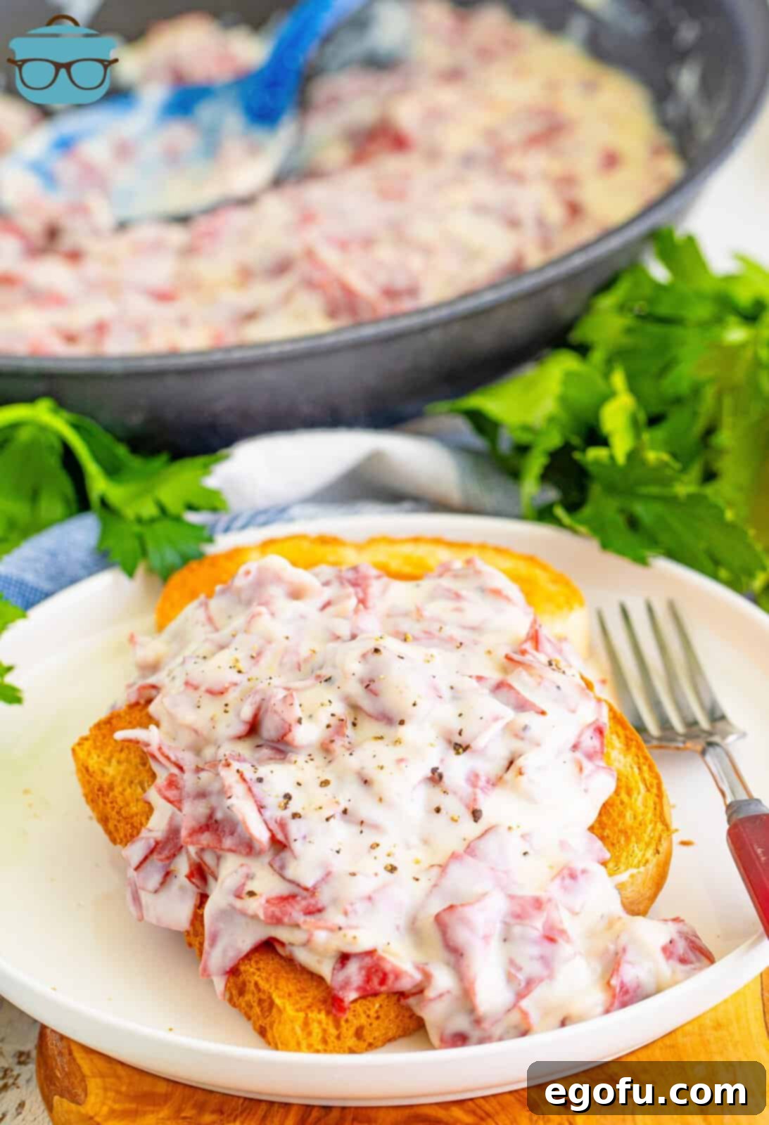Looking down on a few slices of toast covered in Creamed Chip Beef on a plate.