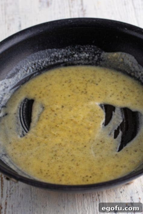 A skillet with pepper, melted butter, and flour in it.