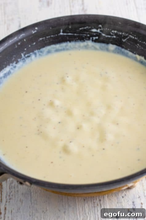 Melted butter, salt, pepper, and flour making a thick sauce in a saucepan.