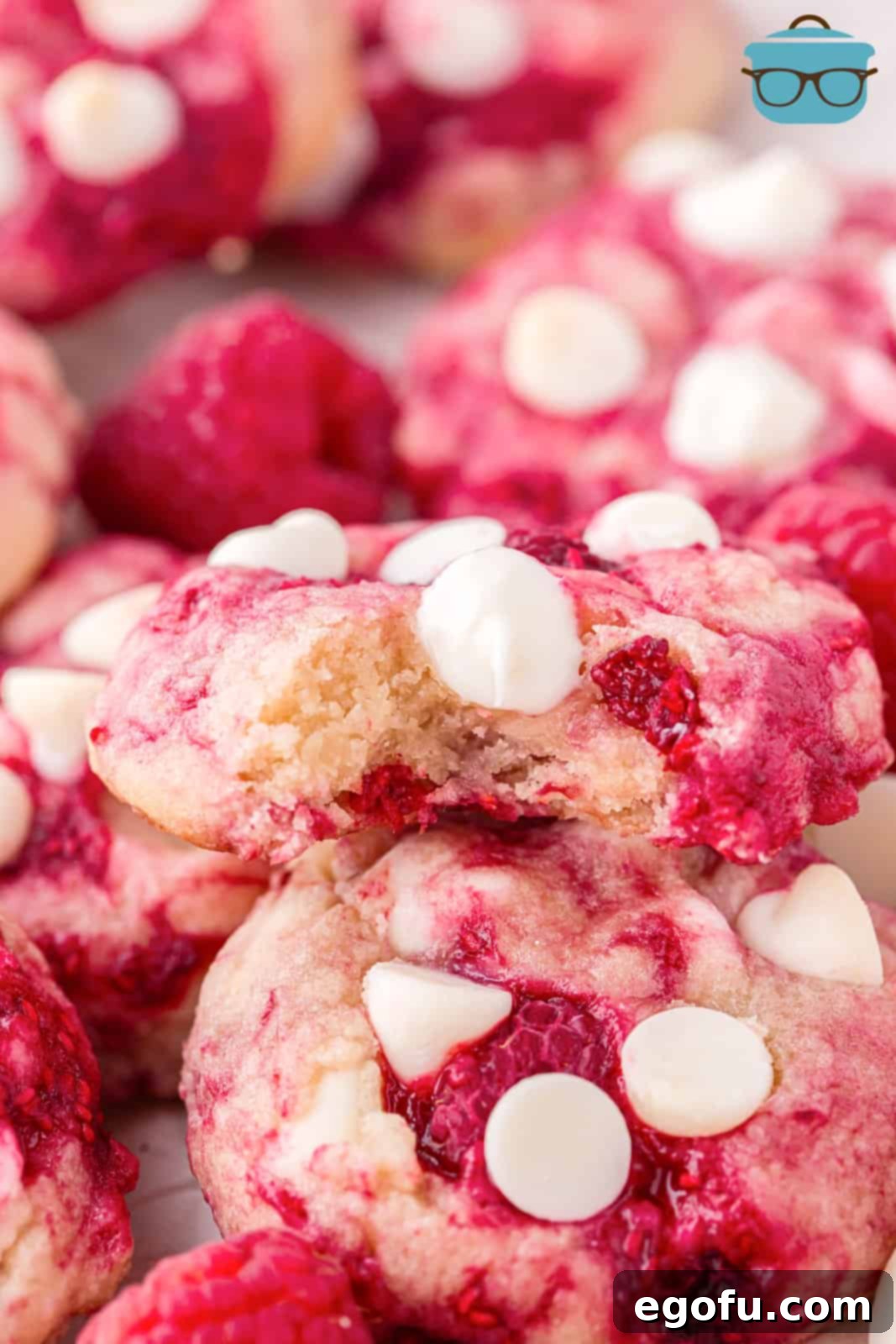 Close up looking at a few Raspberry White Chocolate Cookies, one broken in half.