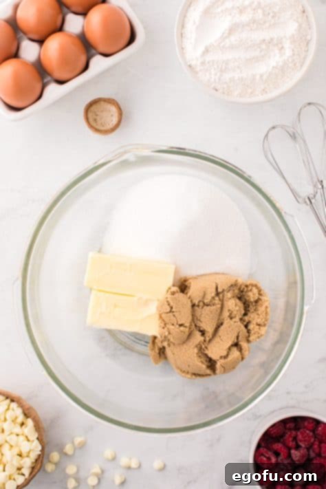 Butter, brown sugar, and white sugar in a glass mixing bowl.