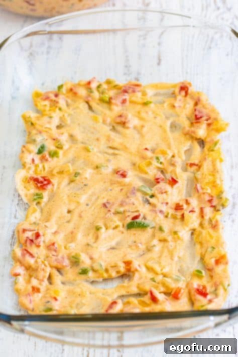 Veggie rich sauce on the bottom of a glass baking dish.