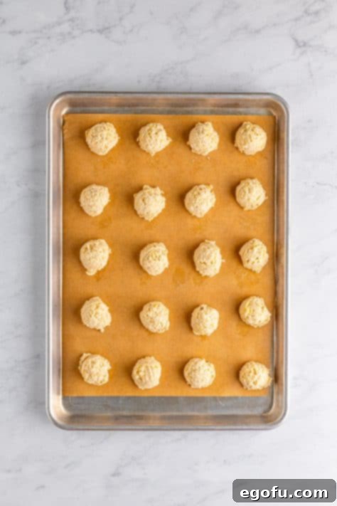 Potato chip cookie dough balls on a baking mat lined baking sheet.