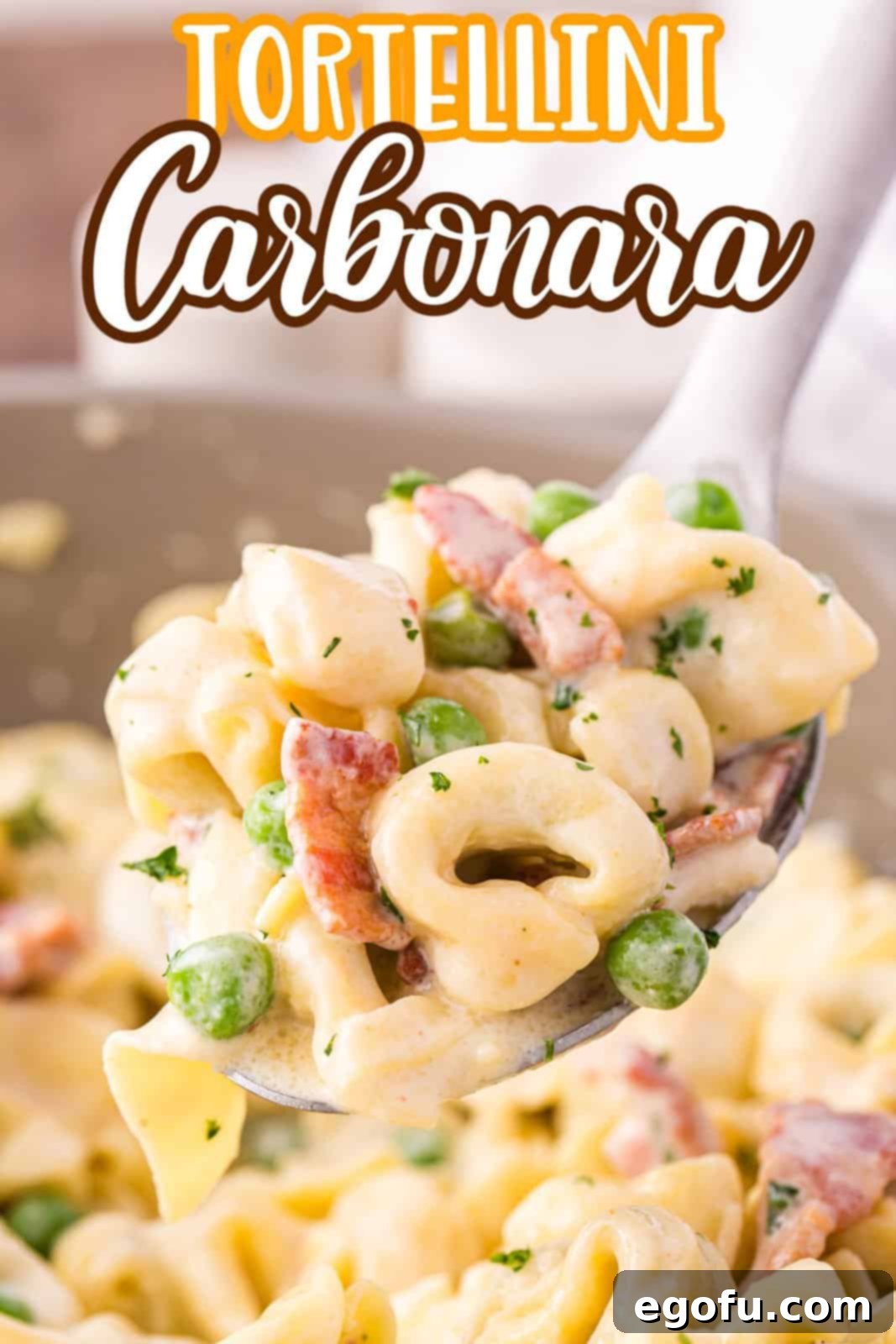 A serving utensil holding a scoop of Tortellini Carbonara, ready to be enjoyed.